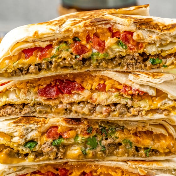 A Crunchwrap is cut and stacked showing the melty, cheesy, crunchy interior.