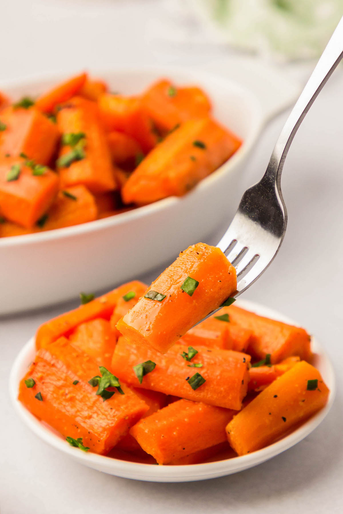 Roasted carrot piece with parsley on a fork