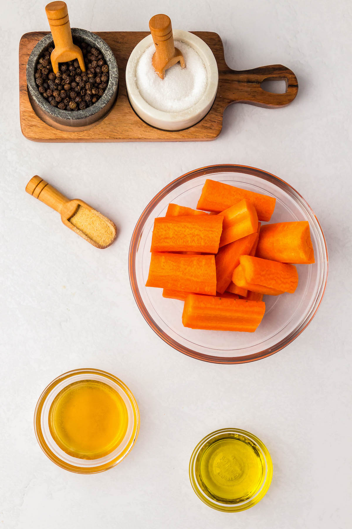Honey, Carrots, Olive Oil, Salt, Pepper, and Garlic powder are laid out in bowls