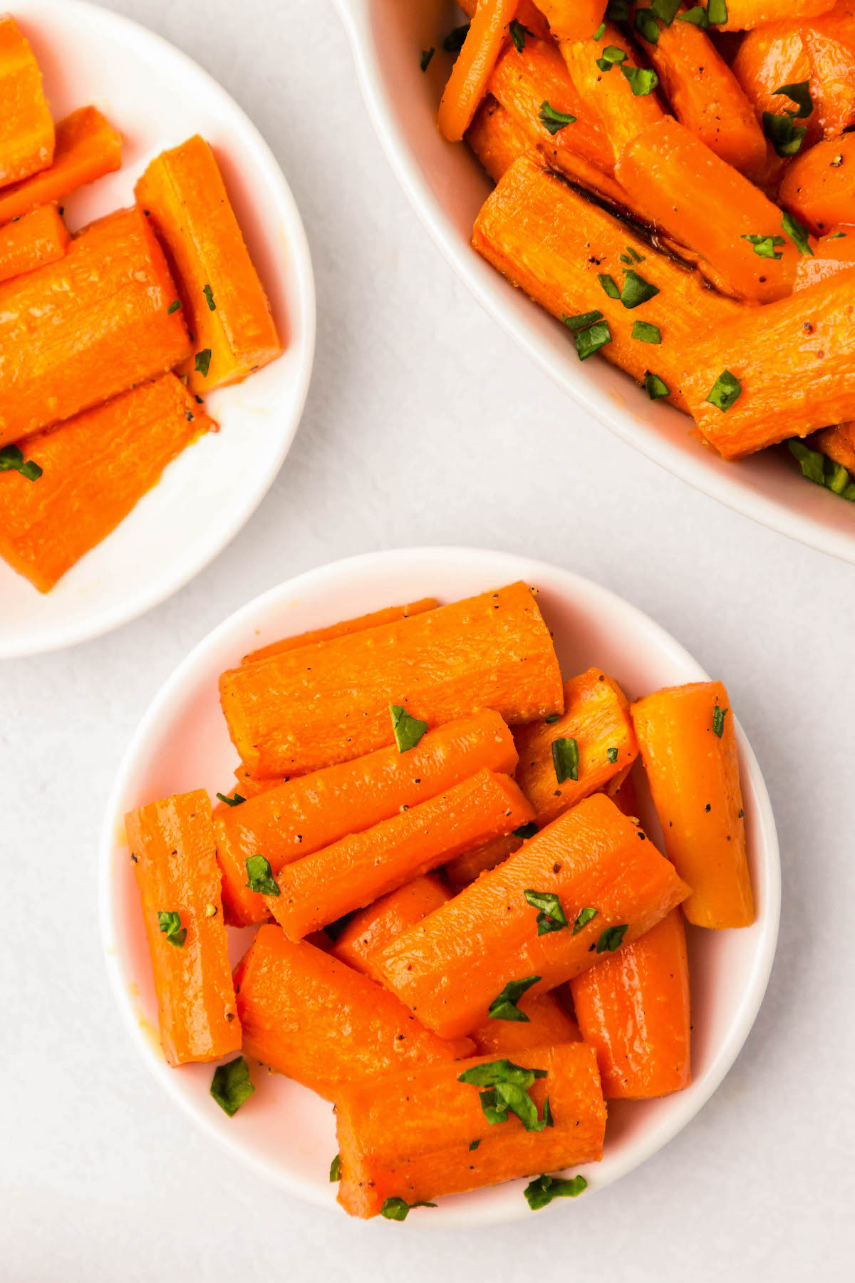 Honey roasted carrots with parsley in a white bowl