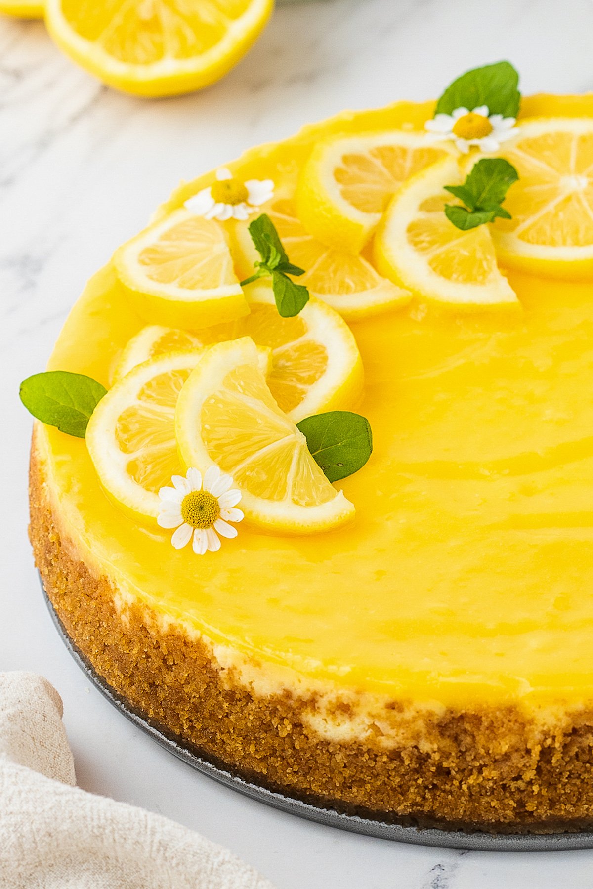 Lemon cheesecake topped with lemon curd and decorative lemon slices.