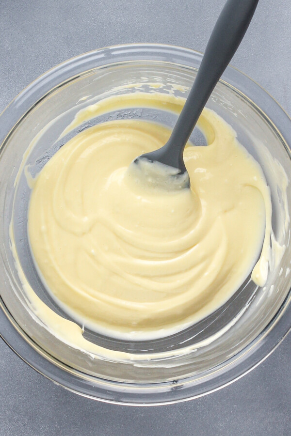Cream cheese filling mixture in a bowl with a spatula.