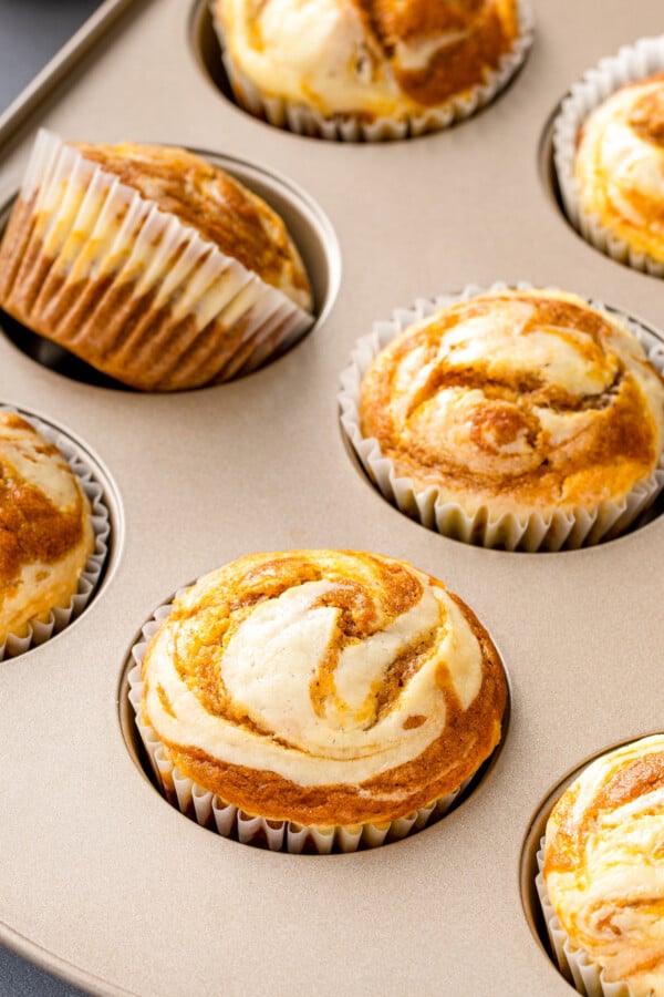 Pumpkin cream cheese muffins in a muffin tin.