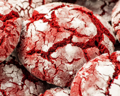 Up close image of red velvet crinkle cookies made with cake mix stacked on top of each other.