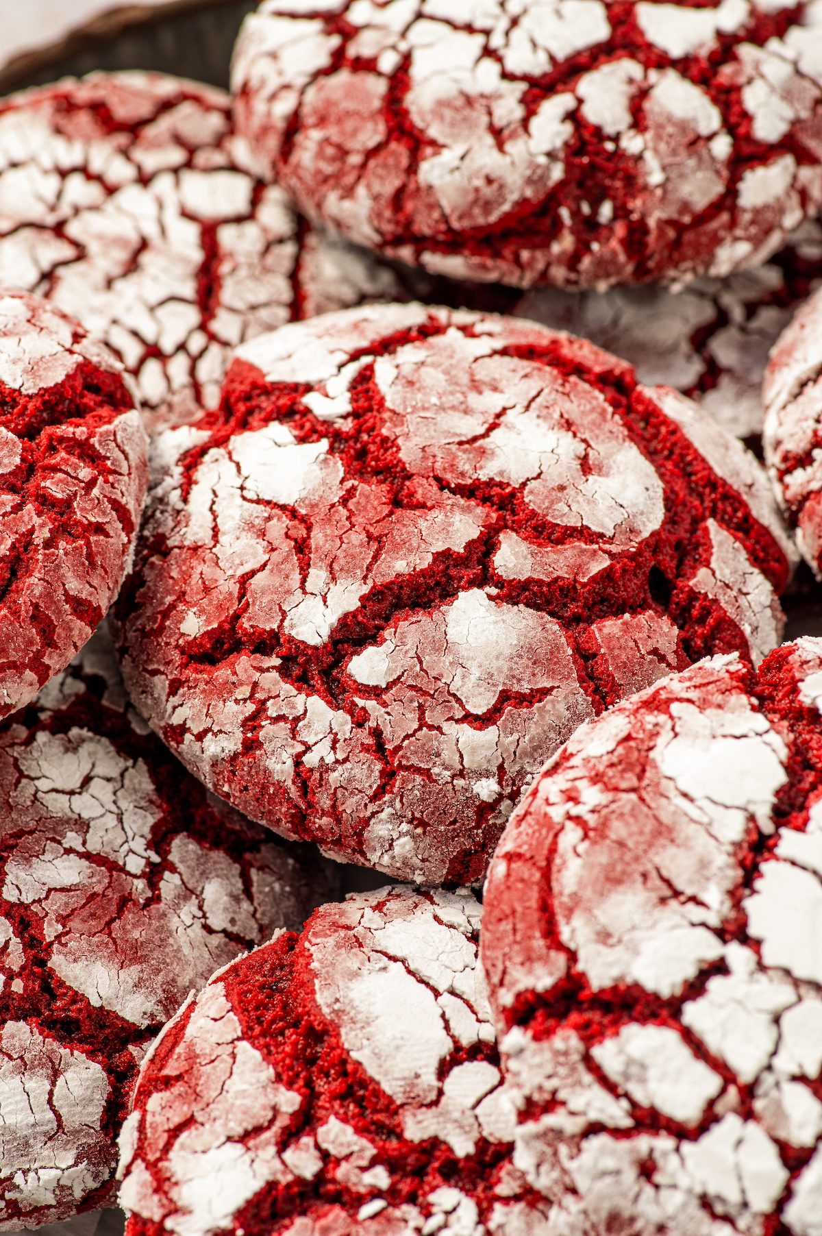 Up close image of red velvet crinkle cookies made with cake mix stacked on top of each other.