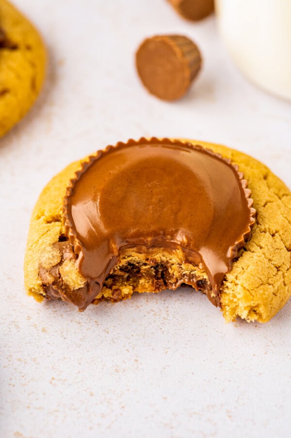A melty Reese's Peanut Butter Cookie with a bite taken out of it.