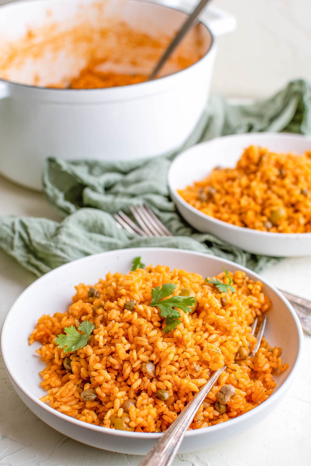 Two bowls of Puerto Rican rice with pigeon peas and a fork inserted in one bowl ready to take a bite.