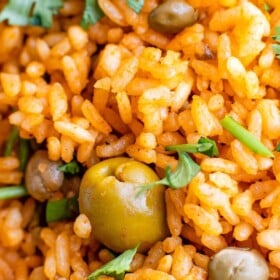 Up close image of arroz con gandules with fresh herbs on top.