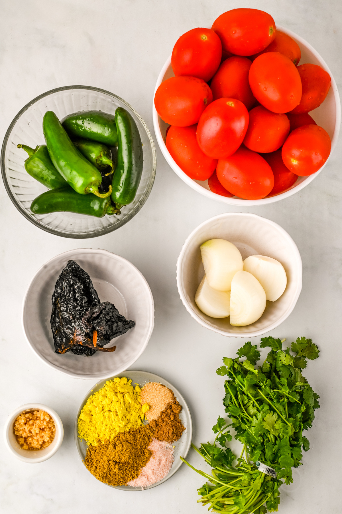Ingredients for the salsa arranged in bowls on a countertop.