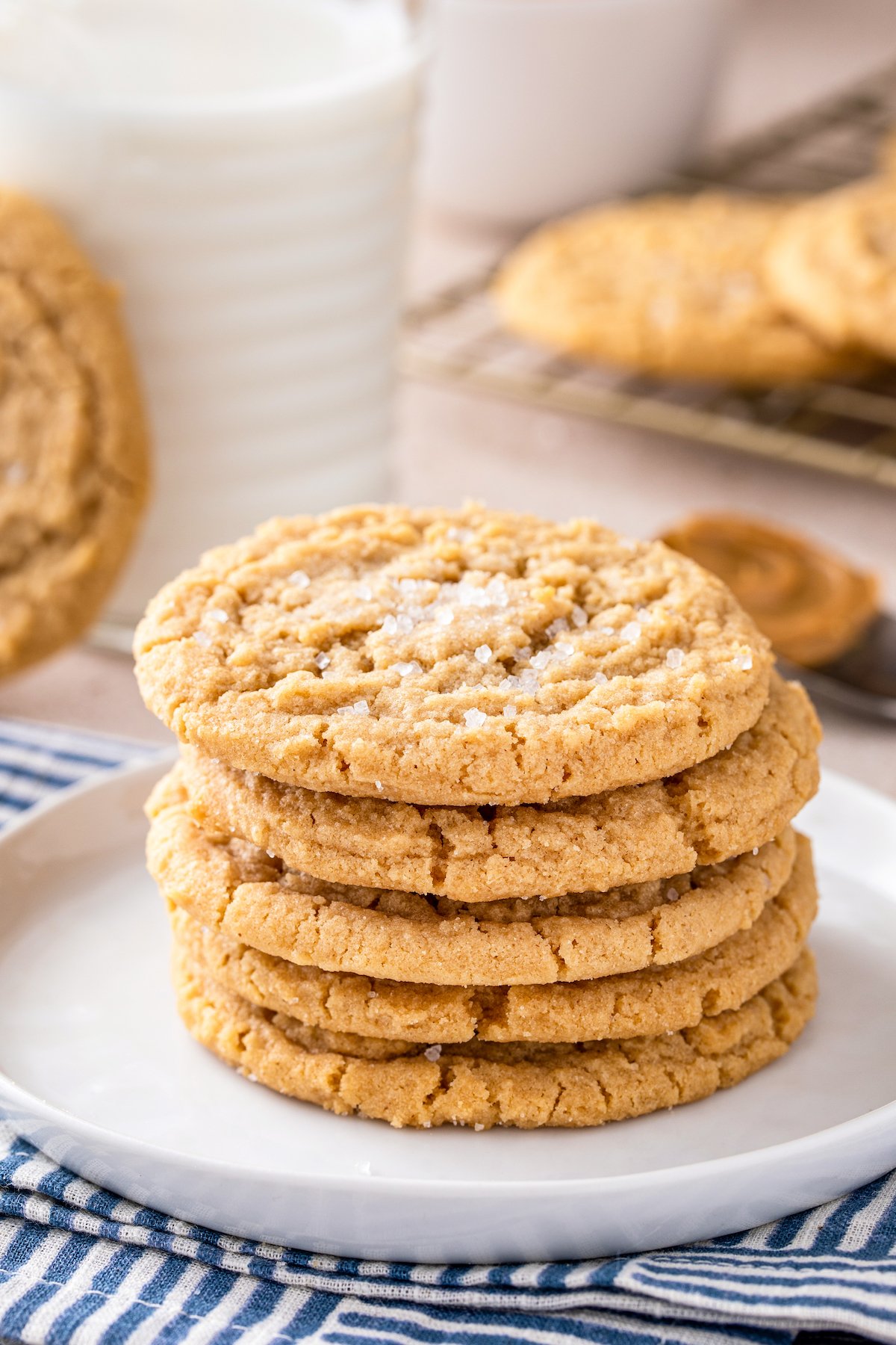 Old fashioned chewy peanut butter cookies stacked on top of each other on a white plate.