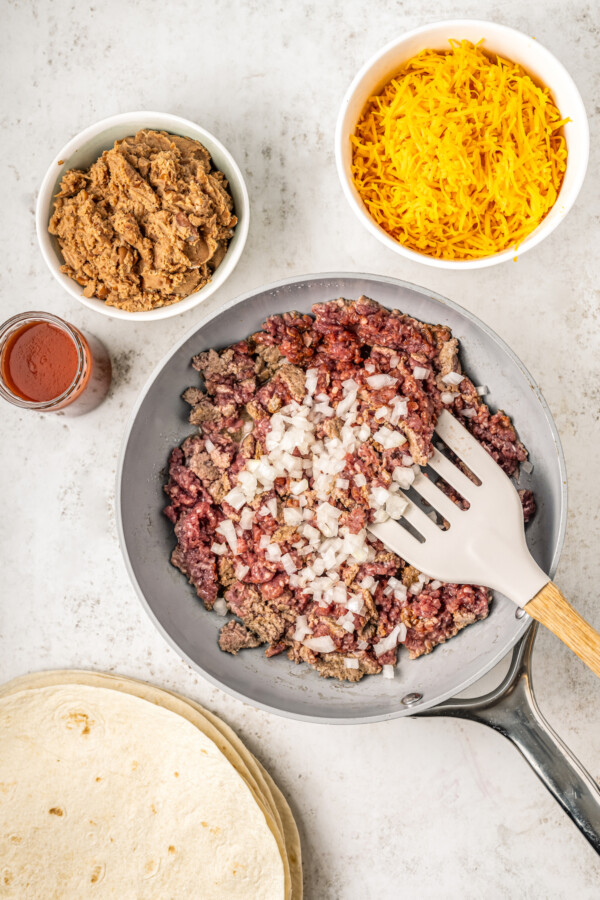 Ground beef, onions and seasonings in a skillet.