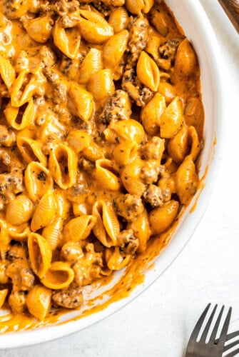 A skillet filled with homemade hamburger helper with ground beef and pasta in a creamy cheese sauce.