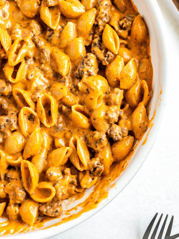 A skillet filled with homemade hamburger helper with ground beef and pasta in a creamy cheese sauce.