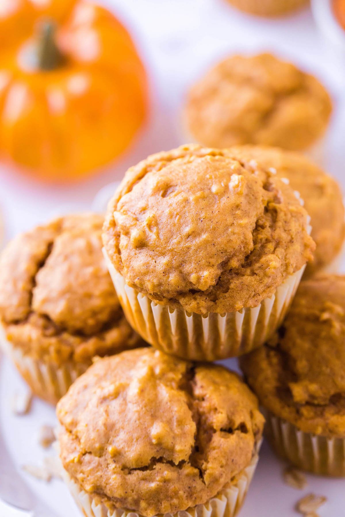 Pumpkin oatmeal muffins stacked on top of each other.