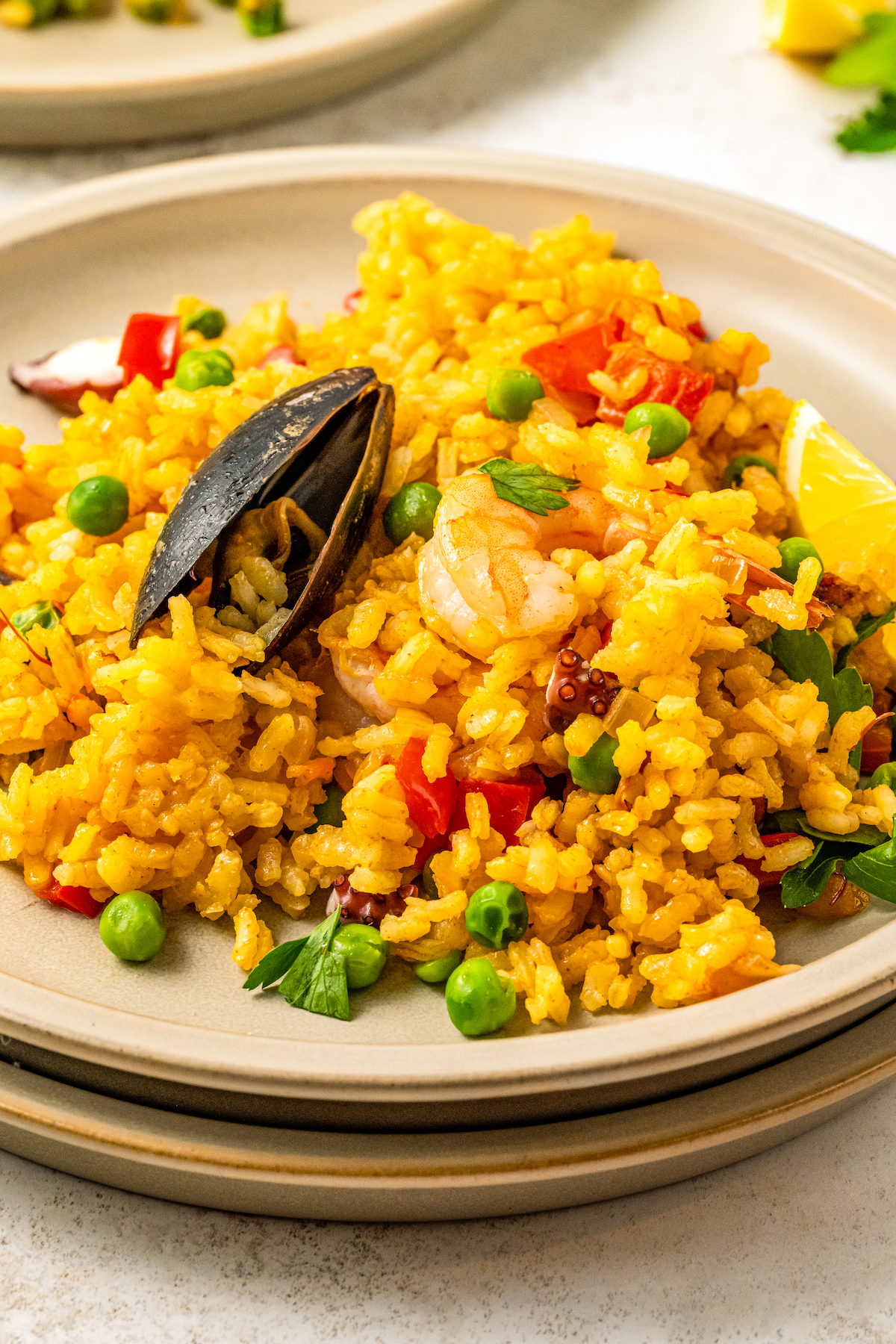 Plate of tender seafood paella with bell peppers and peas. 