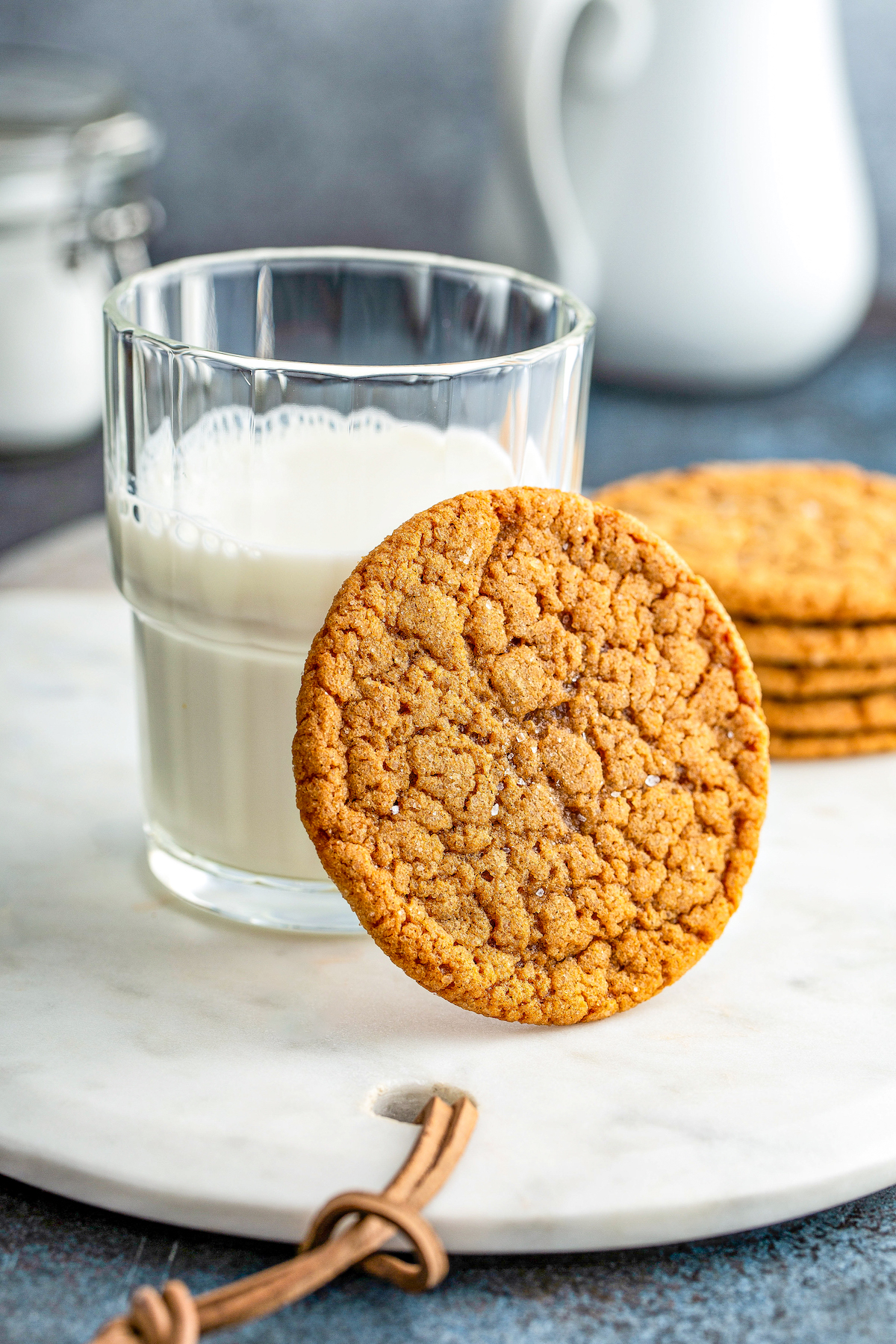 One soft molasses cookie leaning against a glass of milk.