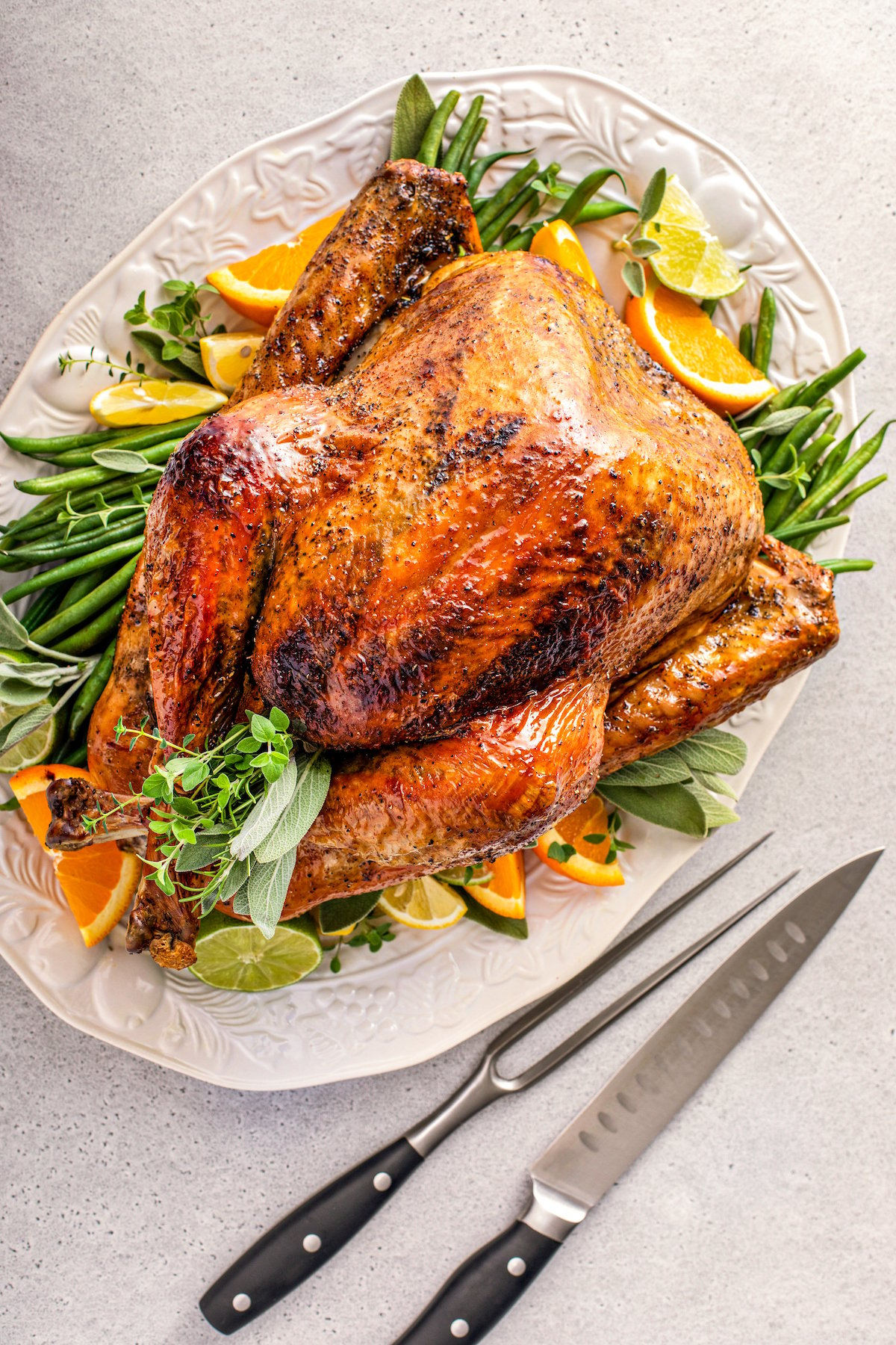 Whole cooked thanksgiving turkey with crispy golden brown skin on a serving platter.