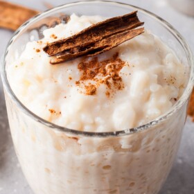 Arroz con leche in a glass jar with cinnamon on top.