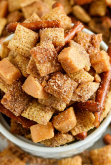 Overhead image of a bowl of cinnamon churro Chex mix with caramel squares and pretzels.