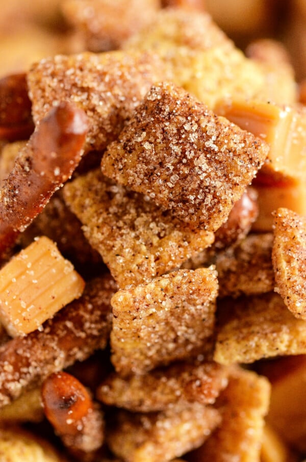 Up close image of glistening cinnamon sugar on pieces of Chex mix.
