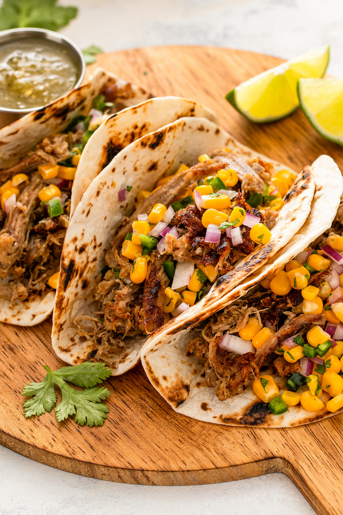 Tacos with carnitas, corn salsa, and red onions. 