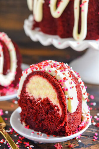 A slice of red velvet bundt cake on a plate with a fork besides the plate.