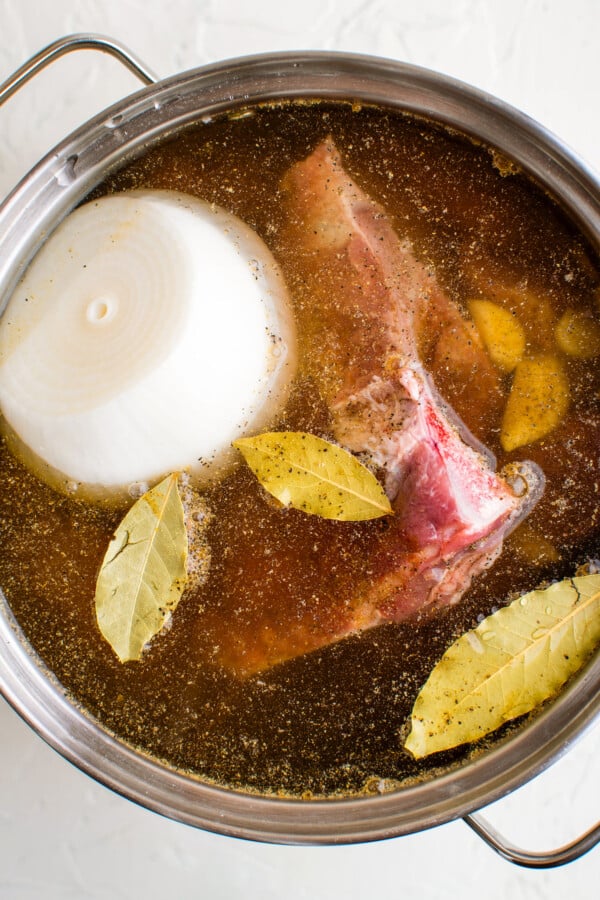 Pork, broth, onion, garlic, seasonings and bay leaves in a large pot.