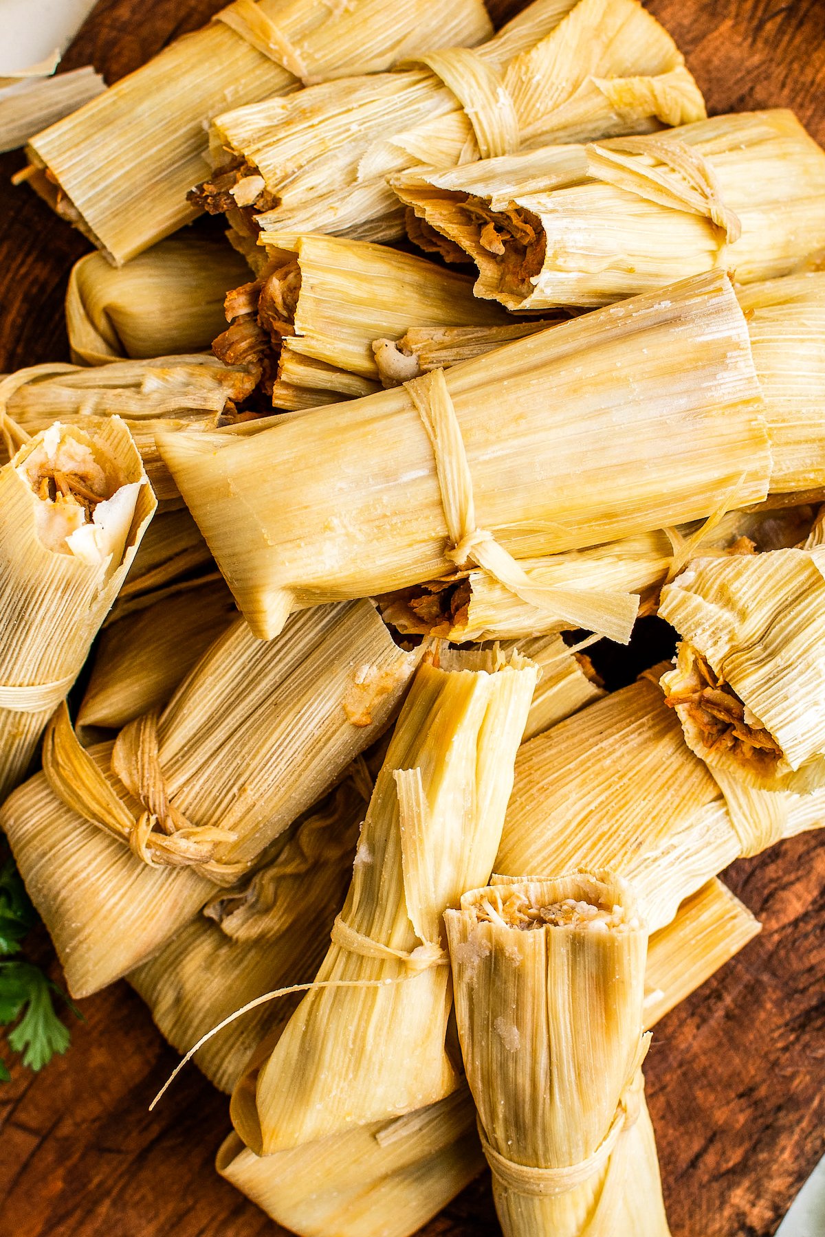 Up close image of homemade tamales wrapped in corn husks.