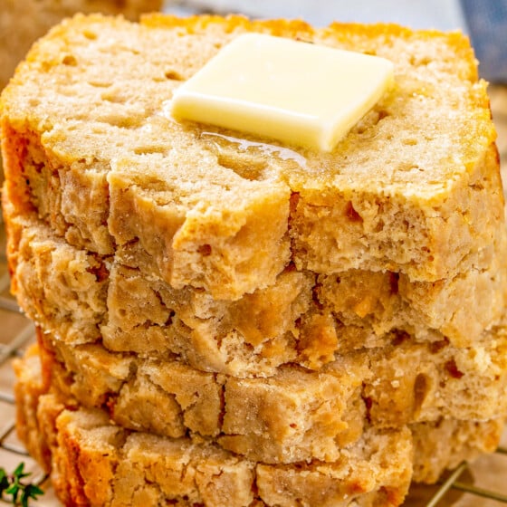 Slices of bread stacked on top of each other showing the edges of the crisp and crackly crust this beer bread recipe creates.