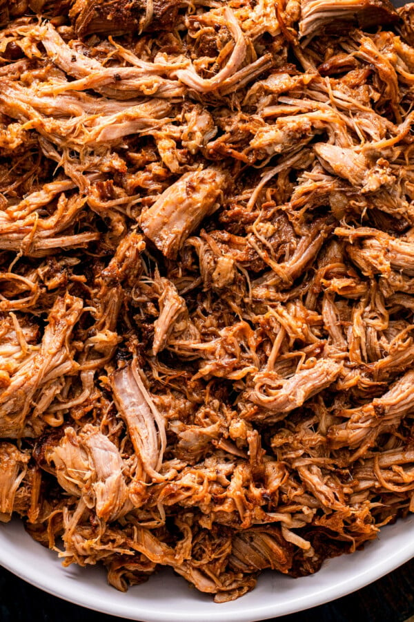 Up close image of crockpot pulled pork coated in bbq sauce in a bowl.