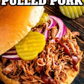 Pulled pork sandwich with pickles and red onions.
