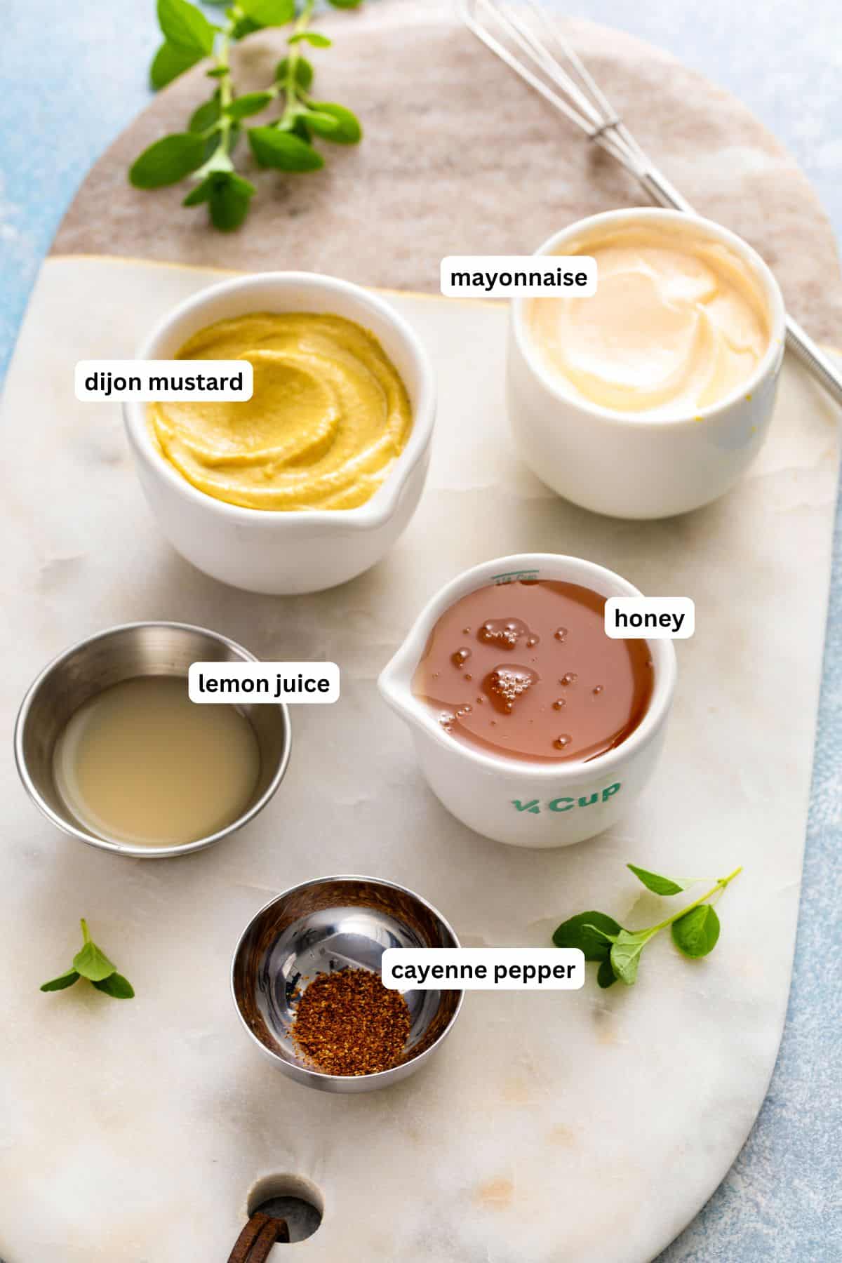 Ingredients for honey mustard recipe in order from top to bottom: dijon mustard, mayonnaise, lemon juice, honey, cayenne pepper.