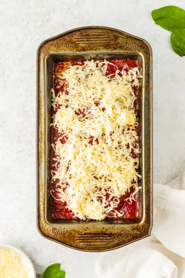 Meatloaf covered with marinara sauce and mozzarella cheese.