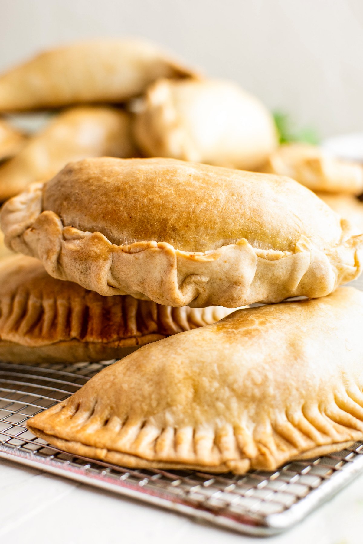 Crisp, golden and flaky empanadas after cooking on a wire cooling rack.