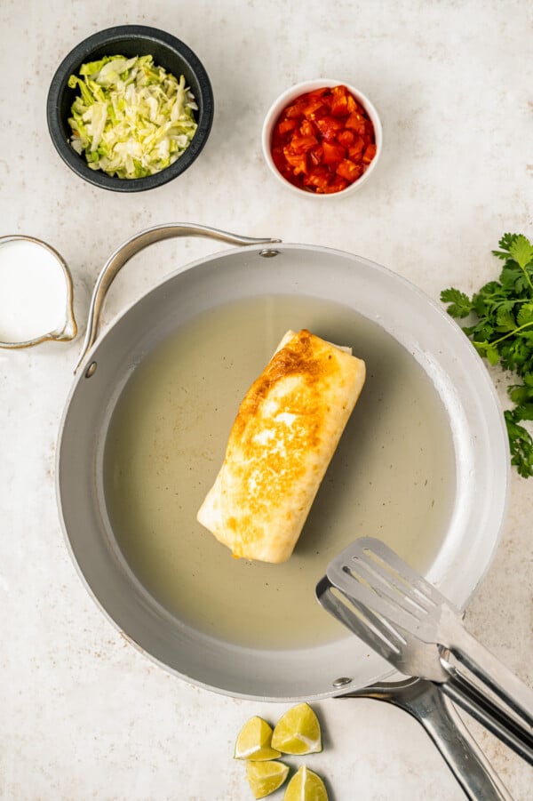 Frying the chimichangas in hot oil in a skillet until crispy. 