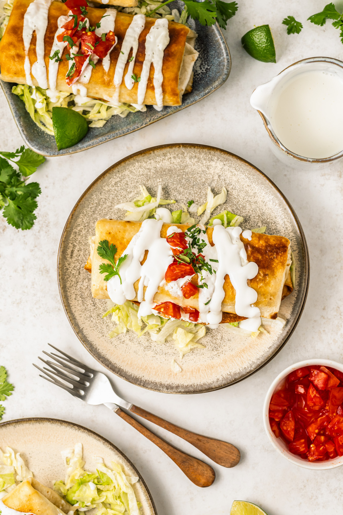 Crispy chicken chimichanga with toppings on a plate. 