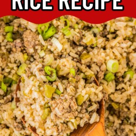 A wooden spoon scooping up a serving of dirty rice out of a pot.