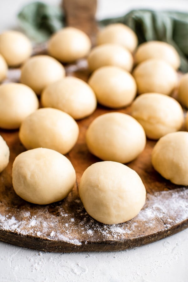 Balls of dough arranged on a cutting board dusted with flour.