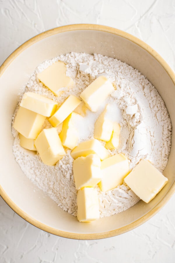Sliced cold butter in a bowl of flour and salt.