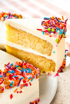 A slice of homemade vanilla cake being lifted with a serving spatula.