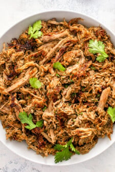 Juicy and tender shredded crock pot carnitas placed in a serving bowl.