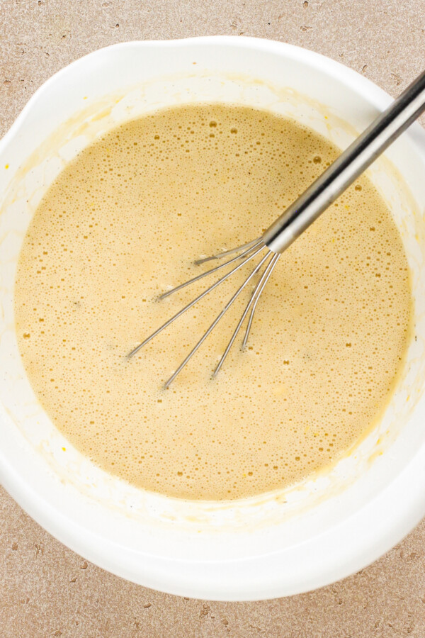 Cake batter being whisked together in a bowl.