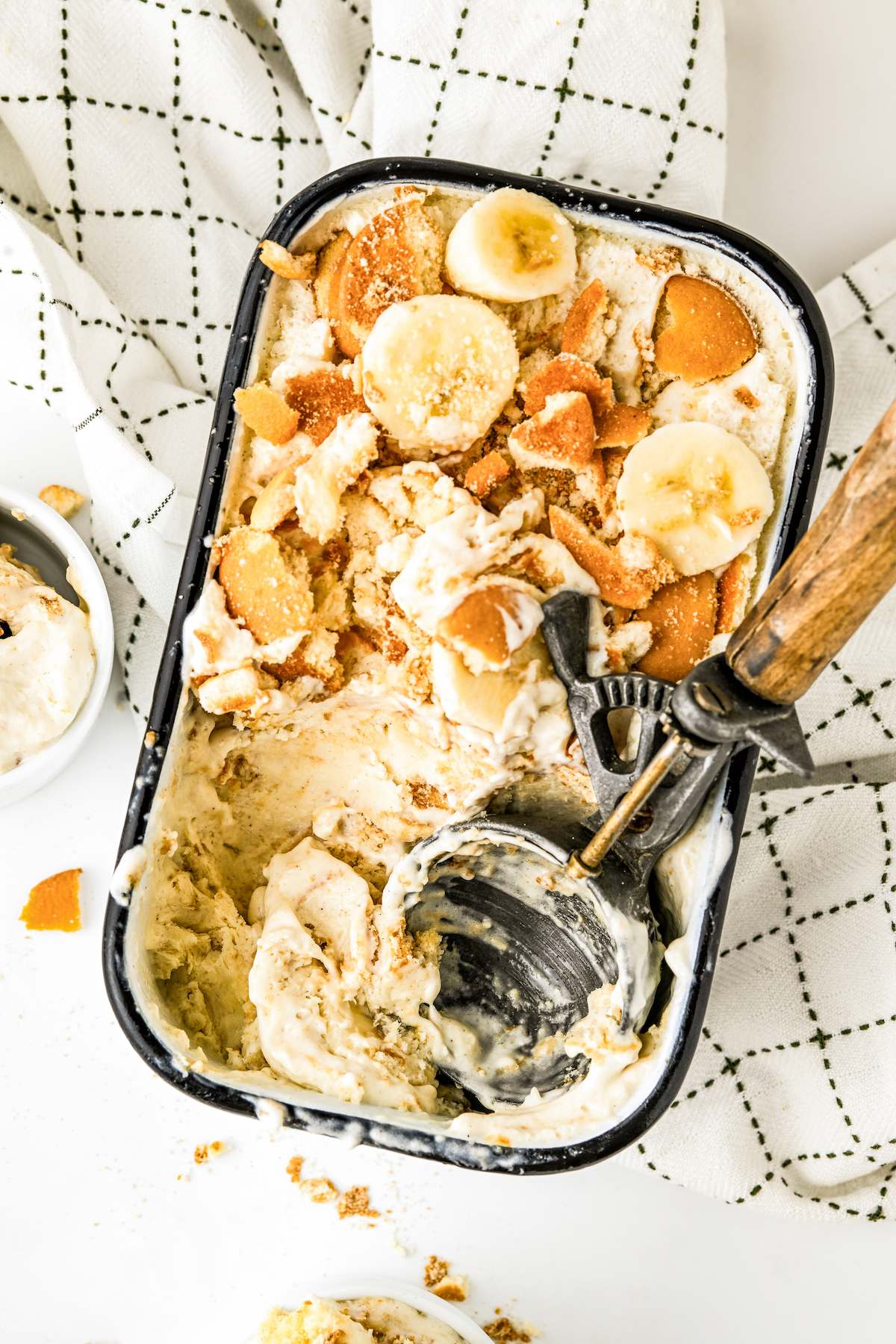 Ice cream scoop in the container of banana pudding ice cream.