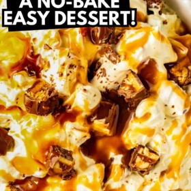 Snickers salad with apples and more in a creamy pudding with caramel drizzled on top.