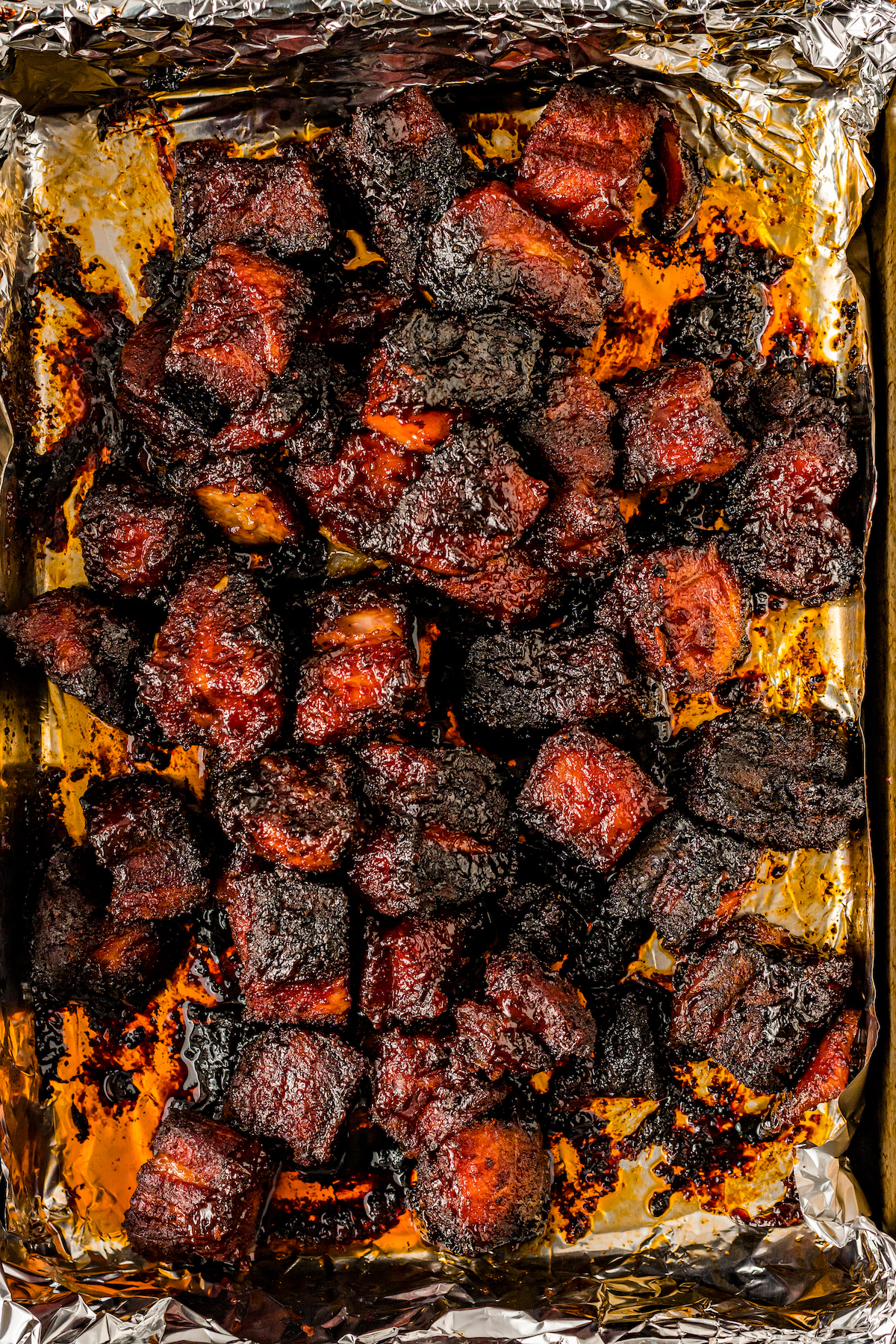 Charred pork belly burnt ends in the baking pan. 