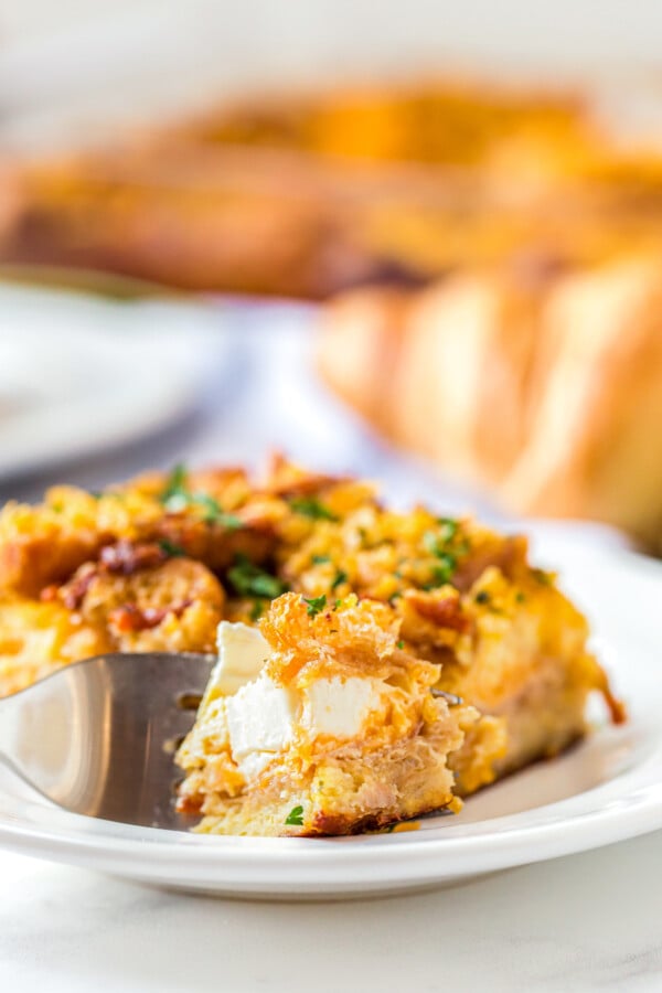 A fork cutting a bite of Ham Breakfast Casserole.