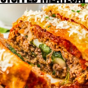 Italian meatloaf stuffed with cheese, prosciutto and spinach sliced into pieces on a serving platter.