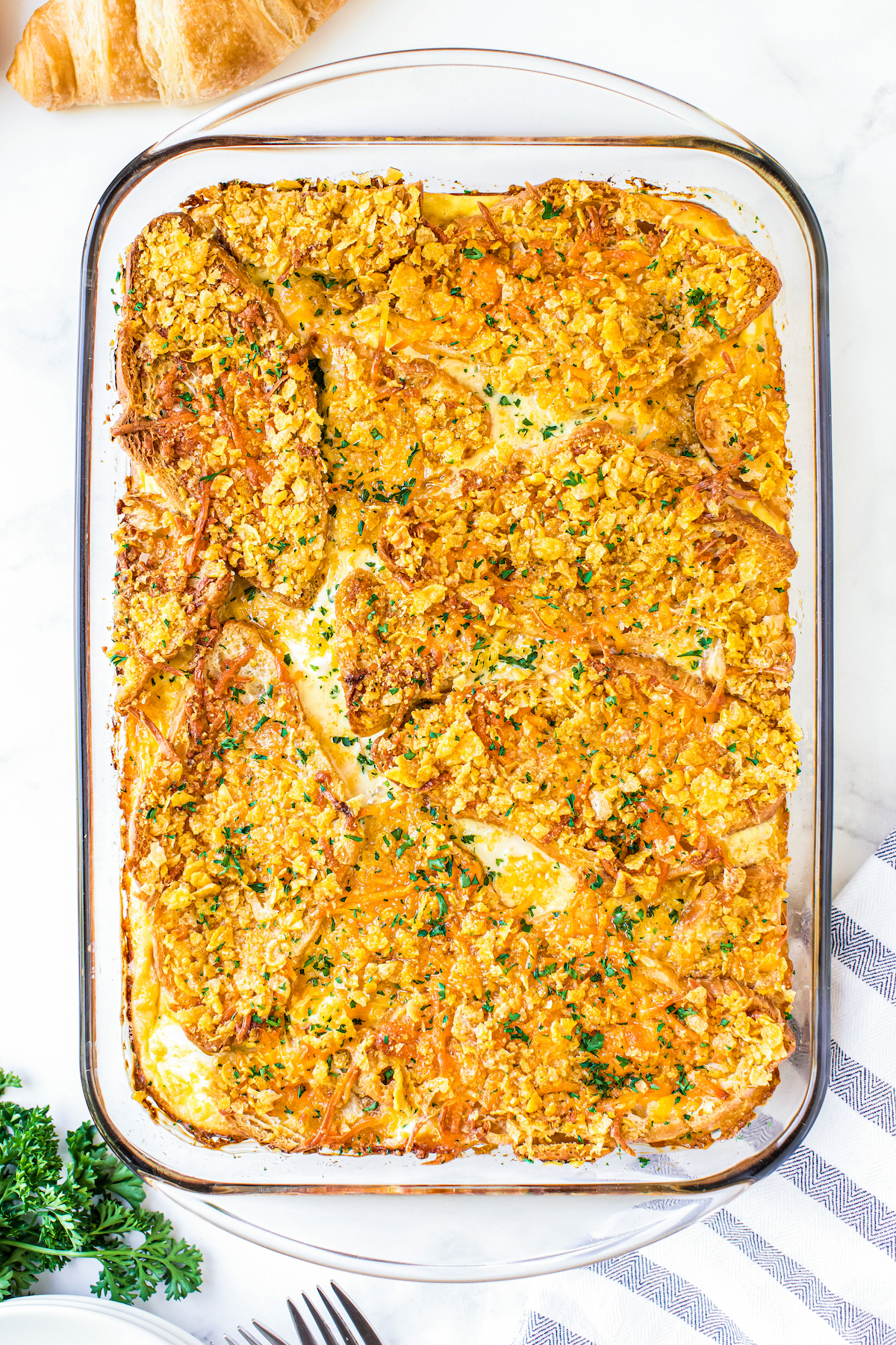 Overnight Breakfast Casserole with Ham in a casserole dish baked with a buttery and crispy cornflake topping.