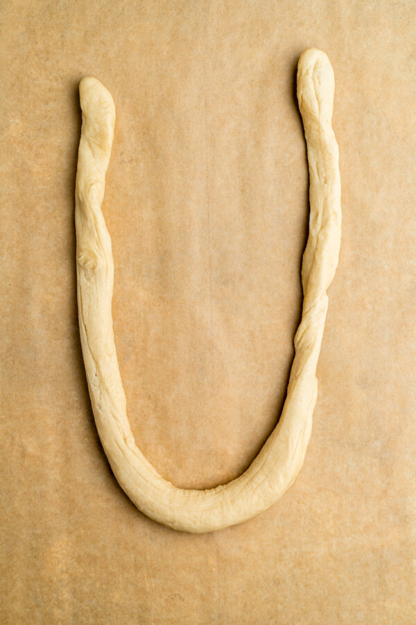 Dough rolled out and formed into a letter u shape.