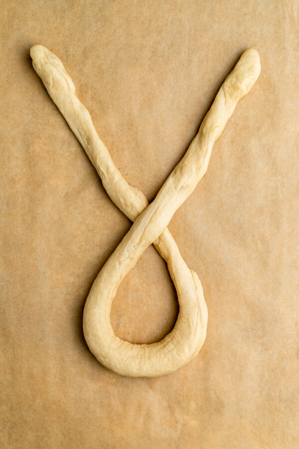 Dough twisted to form an x shape in the middle with a loop at the bottom.